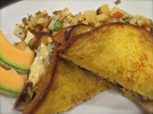 French toast sandwich with melted cheeze, veggie bacun & creole mustard, and potato hash.